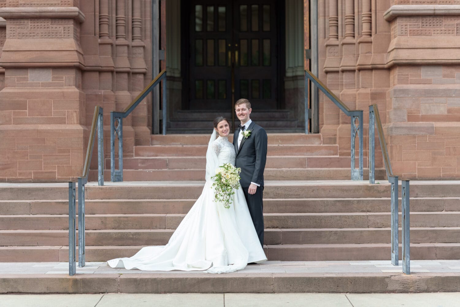 Bride and groom on the steps - Cathedral of Saint John Charleston