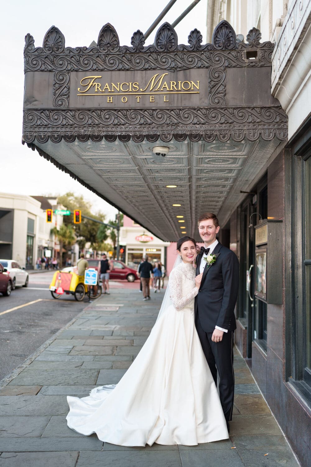 Bride and groom under the Francis Marion hotel awning - Francis Marion Charleston