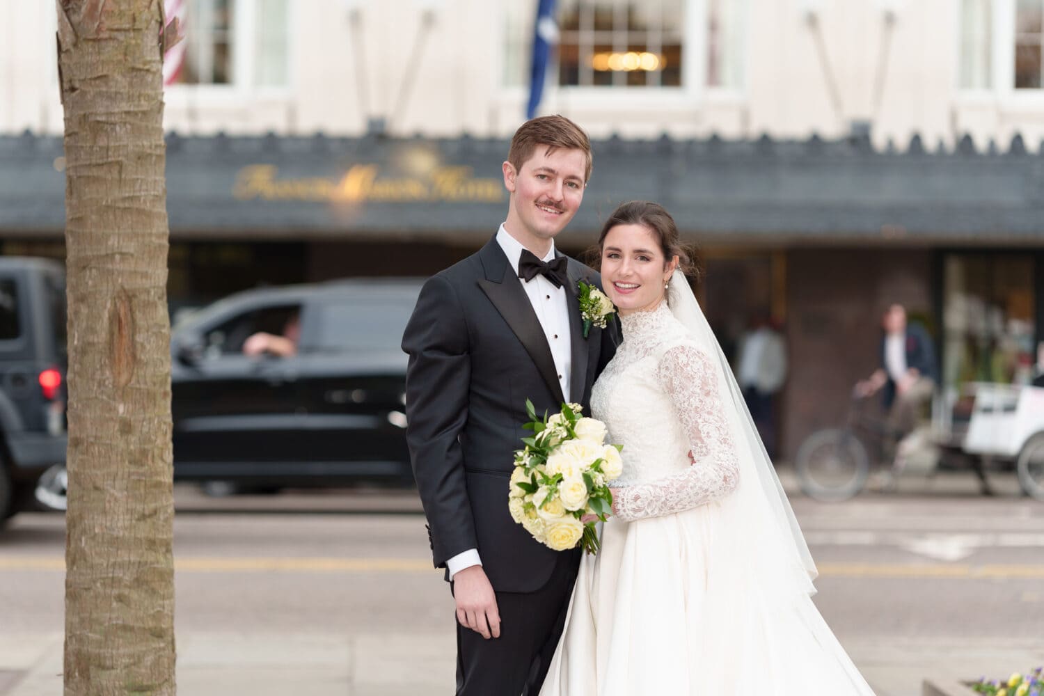 Bride and groom with Francis Marion Hotel in the background - Marion Square Charleston