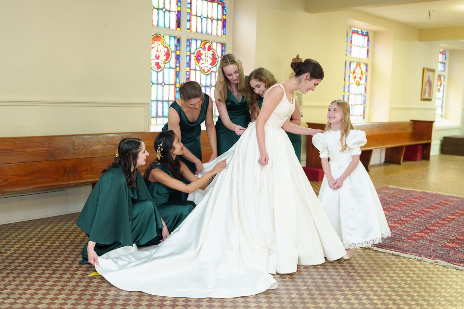 Bridesmaids helping bride with her dress - Cathedral of Saint John Charleston