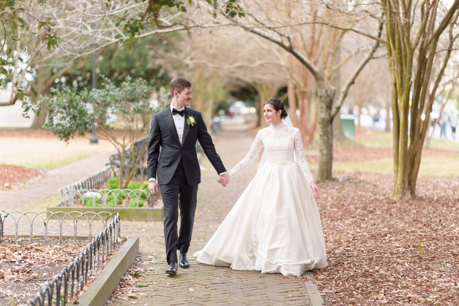 Holding hands walking down the path - Marion Square Charleston