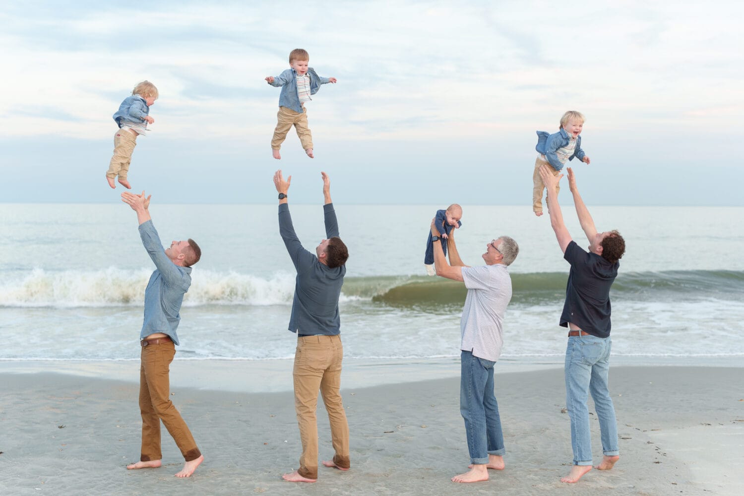 Dads throwing their boys into the air - Huntington Beach State Park