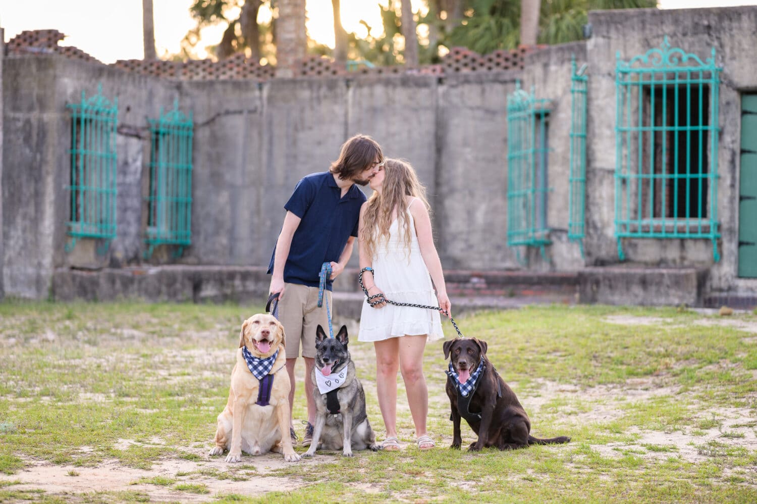 Happy couple with their three dogs for engagement pictures - Huntington Beach State Park