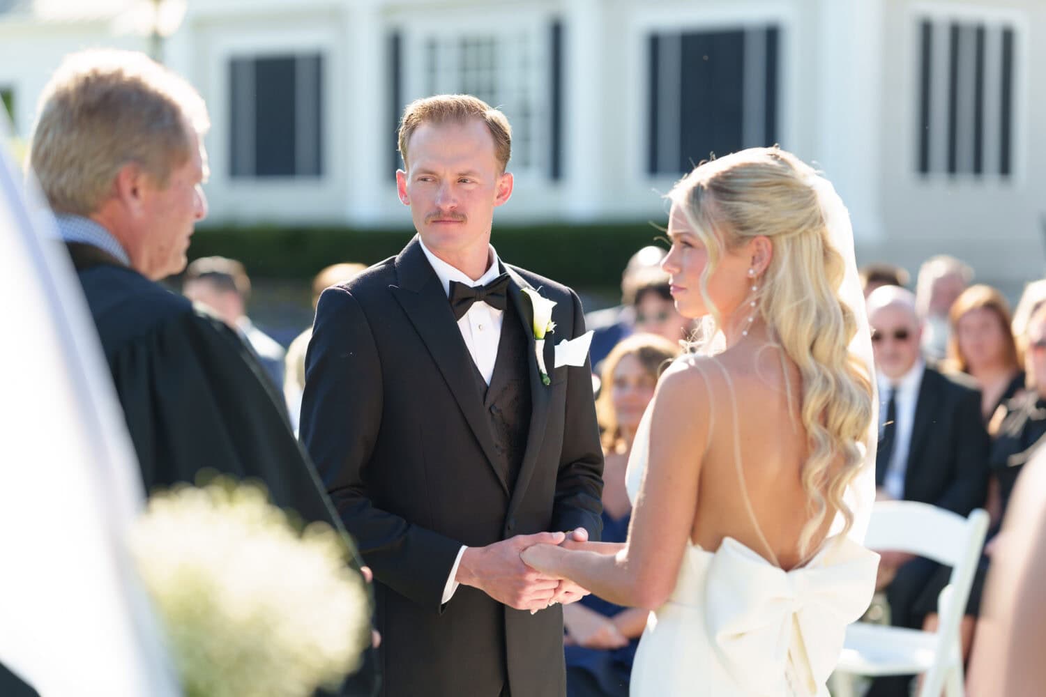 Bride and groom holding hands during the ceremony - Pawleys Plantation