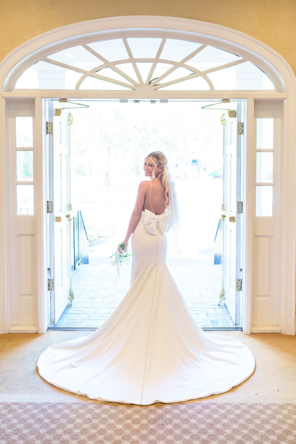 Bride with dress behind her standing in the doorway - Pawleys Plantation
