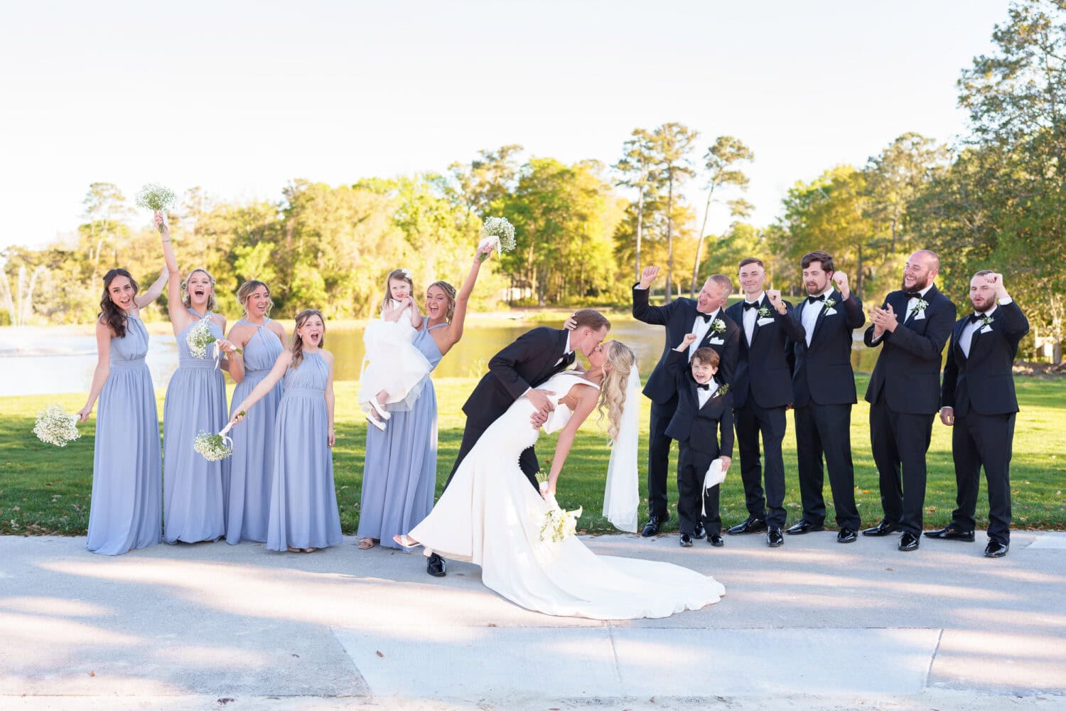 Dip back for a kiss with wedding party cheering - Pawleys Plantation