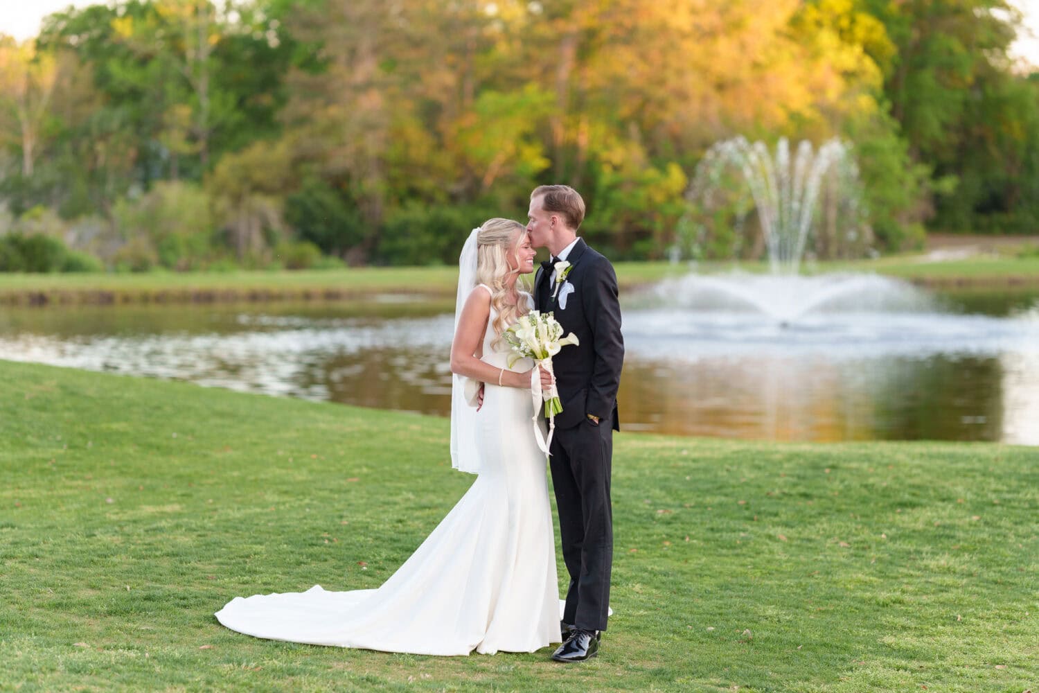 Portraits of the bride and groom in front of the lake and fountain - Pawleys Plantation