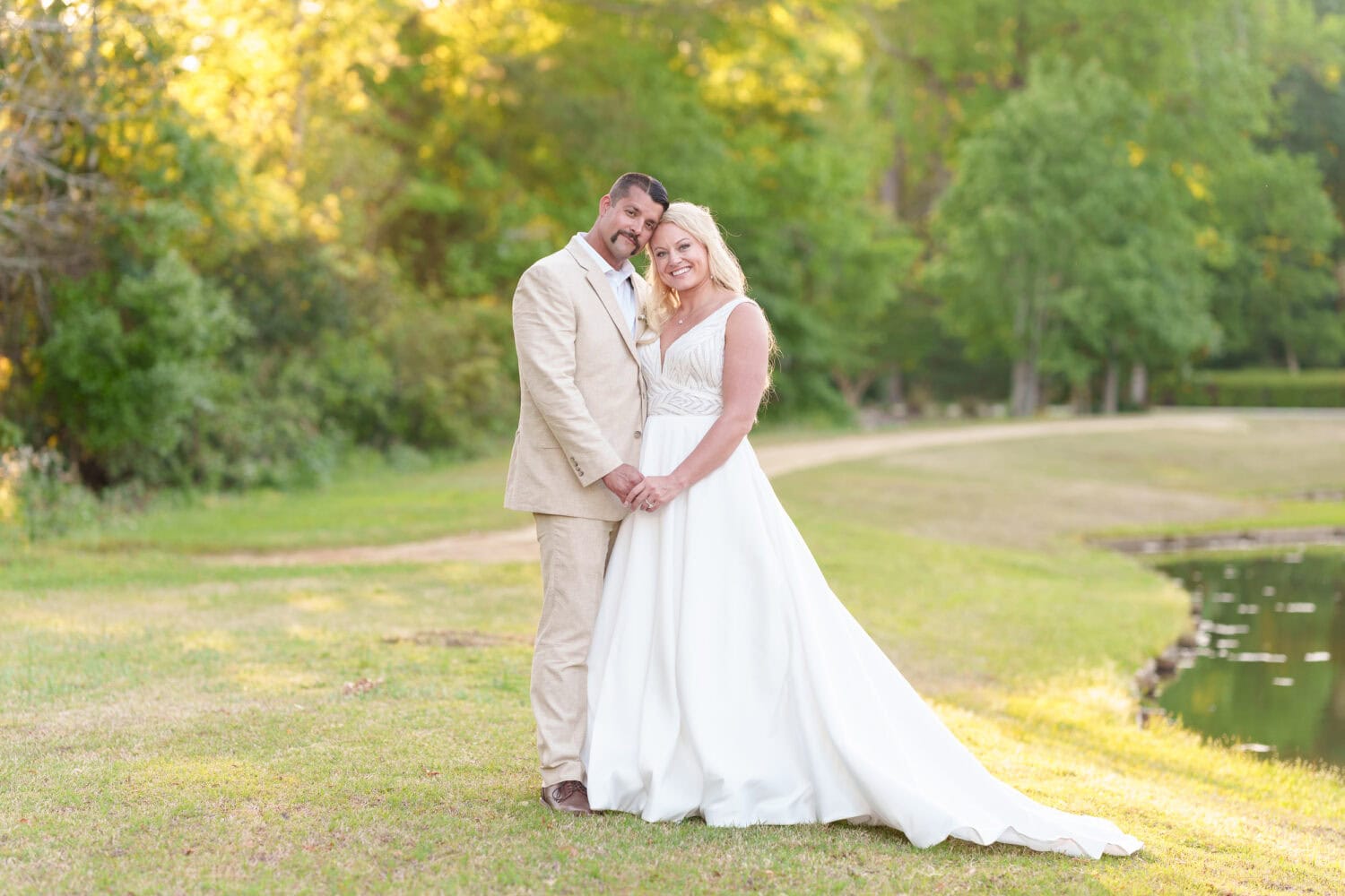 Portraits of the bride and groom by the lake behind the venue - The Village House at Litchfield