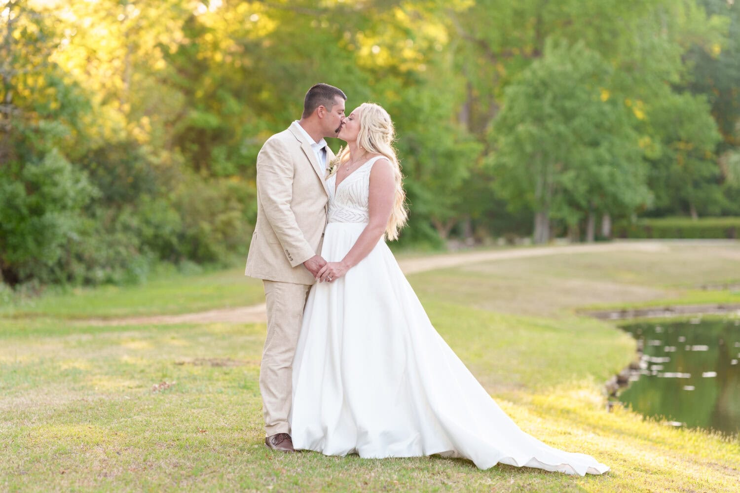 Portraits of the bride and groom by the lake behind the venue - The Village House at Litchfield