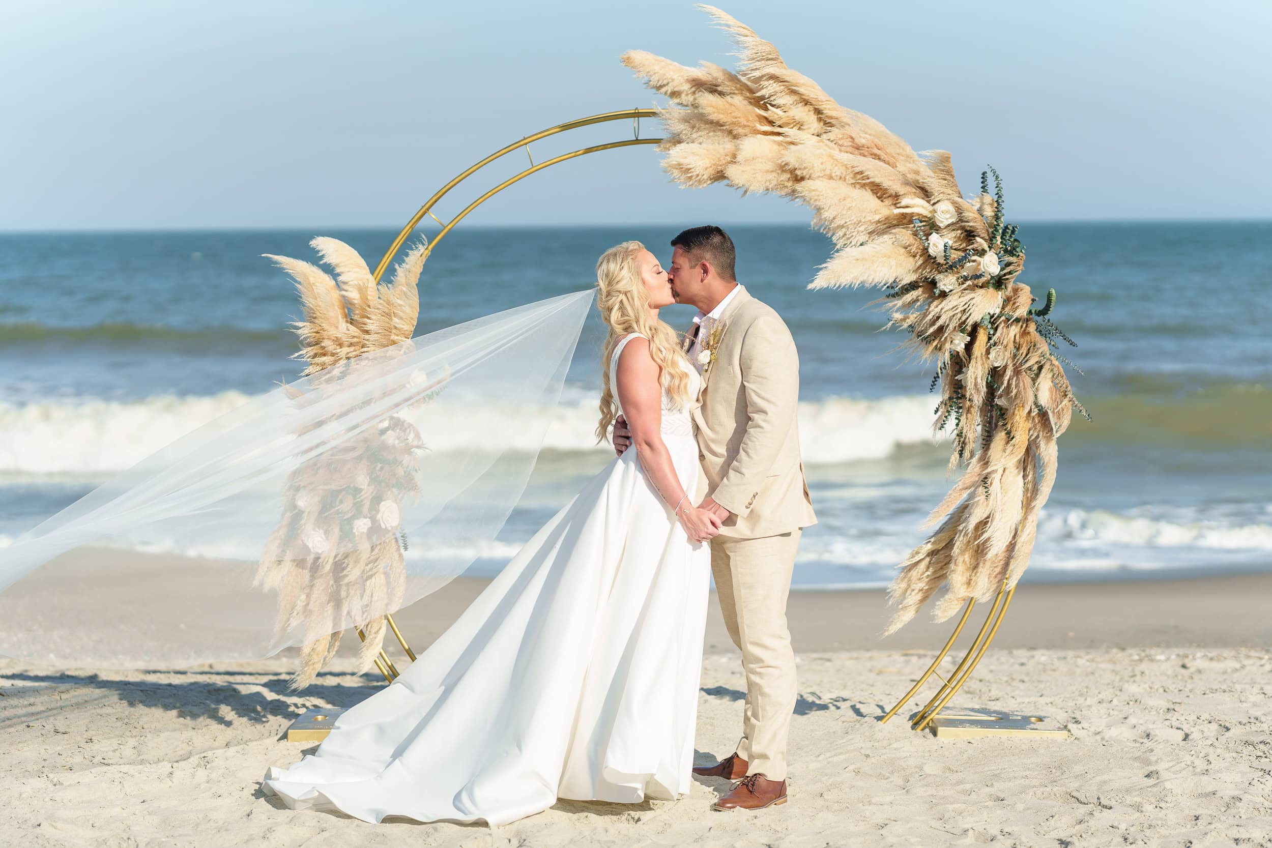 Veil blowing in the wind under the wedding arch in strong direct sun - Beach House in Pawleys Island